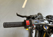Close-up of a Natkie N1 Electric Dirt Bike handlebar with control buttons and throttle grip